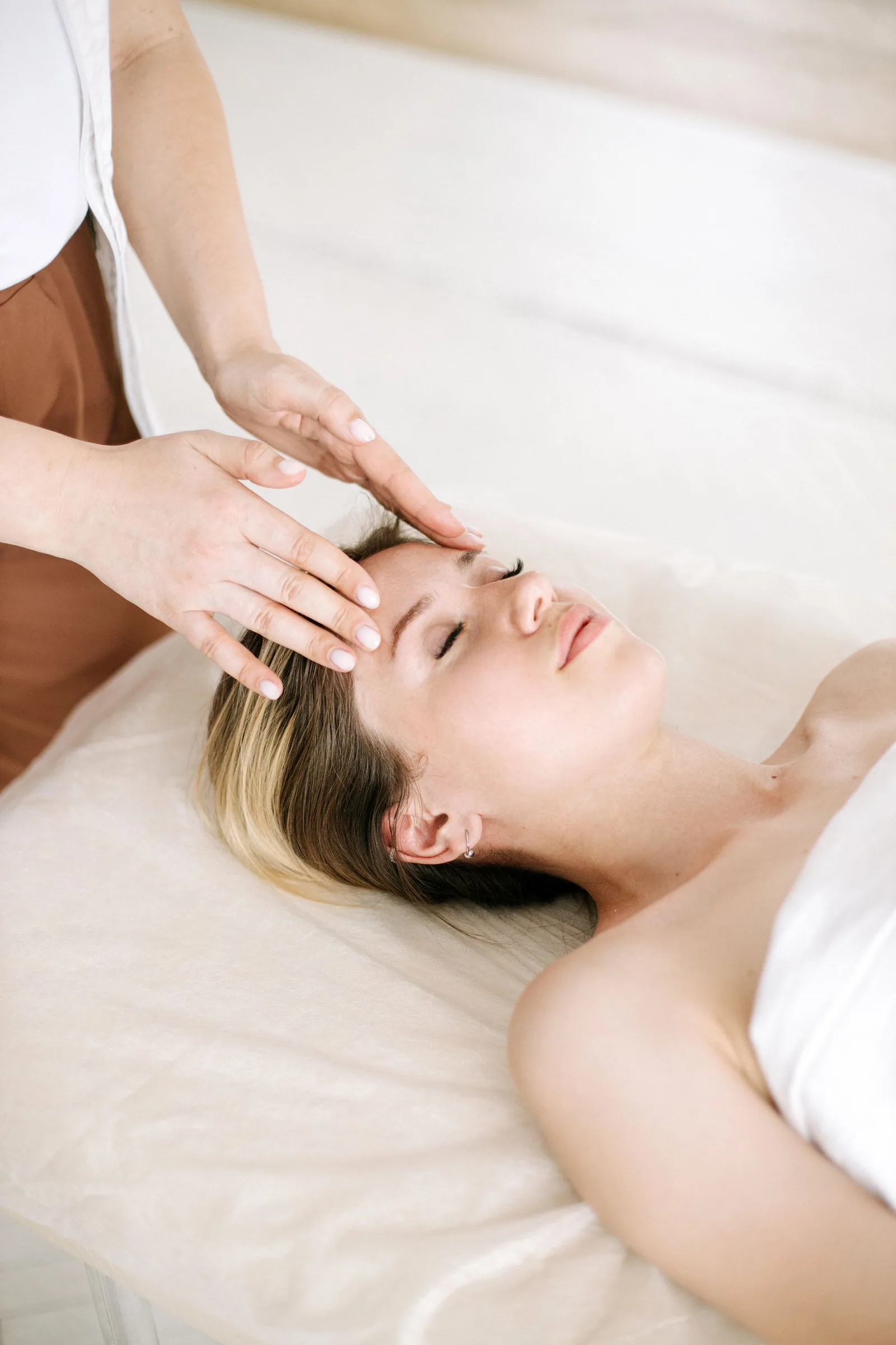Gentle hands held around a resting client's head